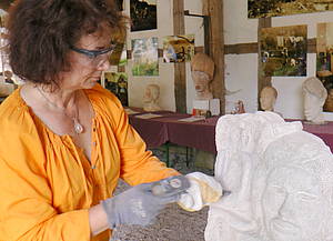 Eine Frau beim Steinbildhauen. Foto: Senger